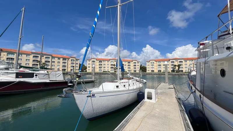 Slide: The Image of 1976 Endeavour 32' Sloop docked at marina with buildings in background. - 3