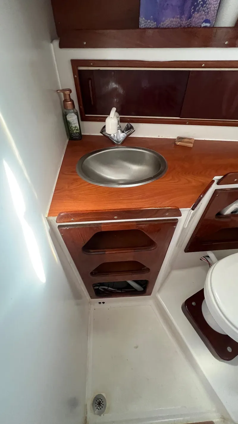 Slide: The Image of 1976 Endeavour 32' Sloop bathroom with sink, wooden cabinetry, and toilet. - 31