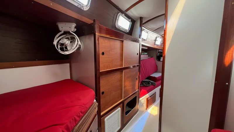 Slide: The Image of Interior of 1976 Endeavour 32' Sloop with red cushions and wooden cabinetry. - 35