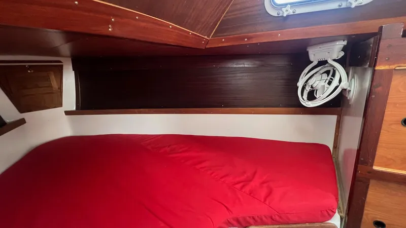 Slide: The Image of Cozy cabin interior of 1976 Endeavour 32' Sloop with red bedding and wooden accents. - 36