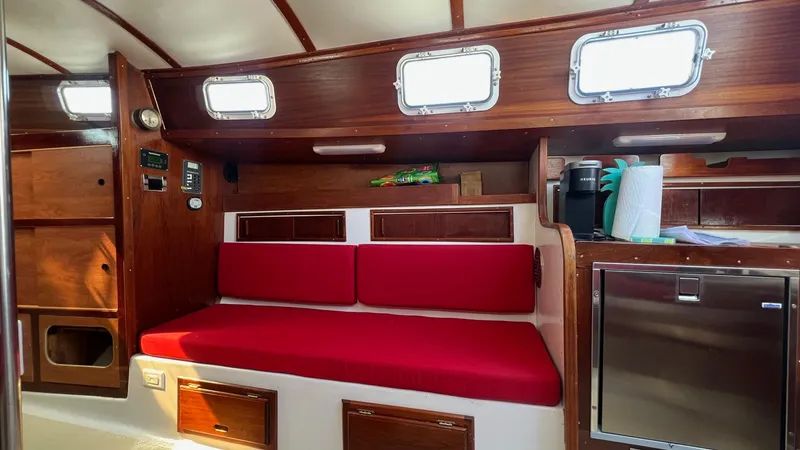 Slide: The Image of Interior of 1976 Endeavour 32' Sloop with red cushions and wooden cabinetry. - 39