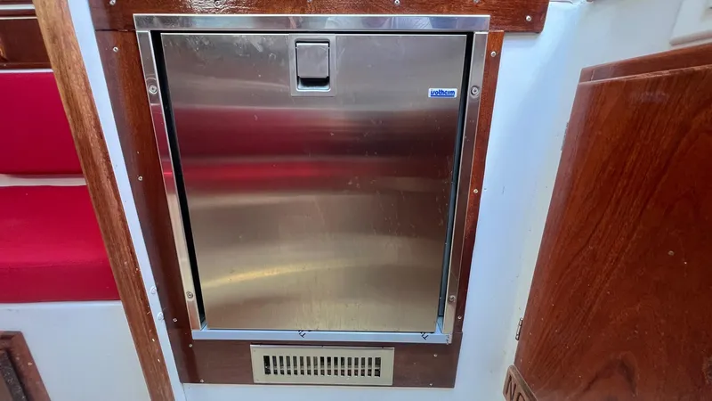 Slide: The Image of Stainless steel fridge on 1976 Endeavour 32' Sloop, surrounded by wood paneling. - 41