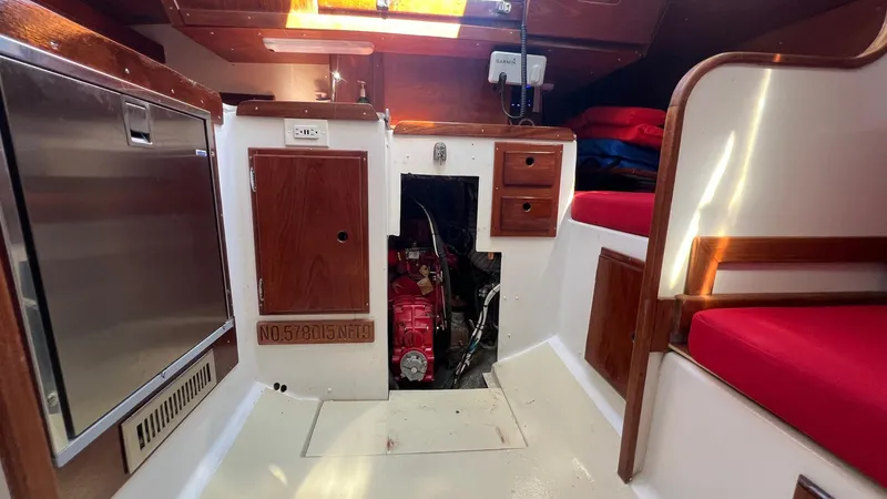 Slide: The Image of Interior of a 1976 Endeavour 32' Sloop, featuring engine access and red seating. - 44