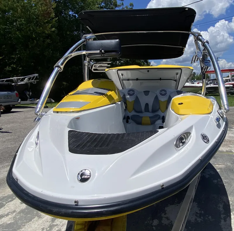 Slide: The Image of 2006 Sea-Doo Sportster boat with yellow accents and canopy, parked outdoors. - 5