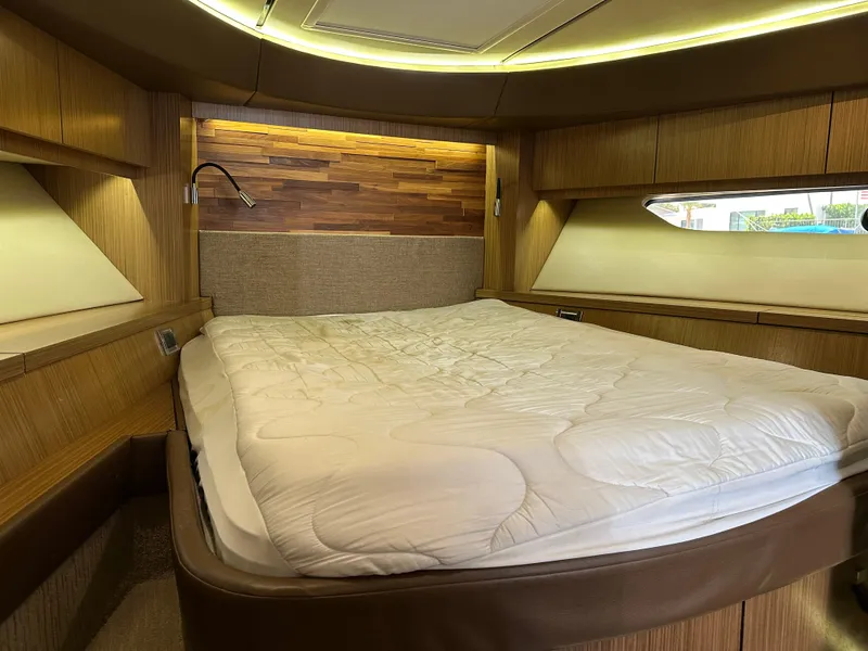 Slide: The Image of Luxurious cabin interior of 2016 Sea Ray L590 yacht with cozy bed and wooden accents. - 14