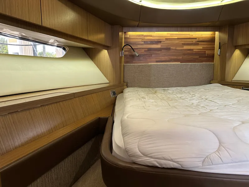 Slide: The Image of Luxurious 2016 Sea Ray L590 yacht bedroom with wood accents and cozy bedding. - 15