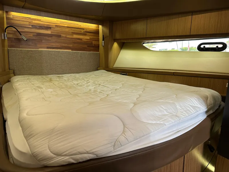 Slide: The Image of Luxurious cabin interior of 2016 Sea Ray L590 yacht with cozy bed and wooden accents. - 16