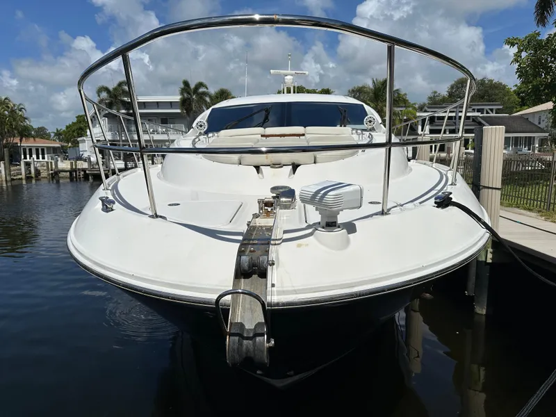Slide: The Image of 2016 Sea Ray L590 yacht docked, front view with clear sky and waterfront homes. - 28