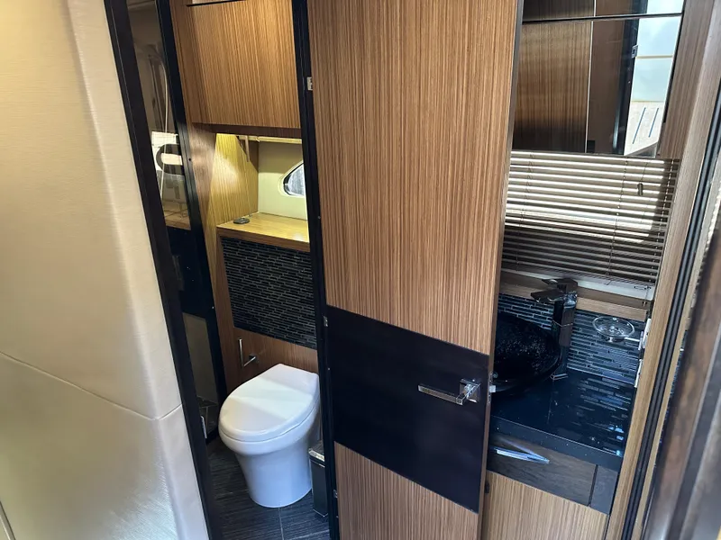 Slide: The Image of Luxurious bathroom interior of 2016 Sea Ray L590 yacht, featuring modern fixtures and wood accents. - 43