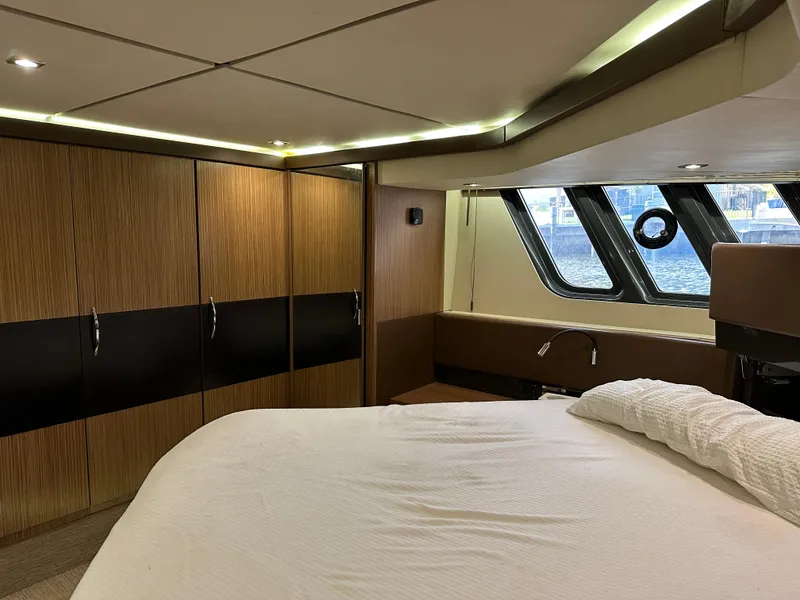 Slide: The Image of Luxurious 2016 Sea Ray L590 yacht bedroom with modern wood paneling and large windows. - 48