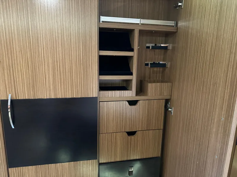 Slide: The Image of Wooden storage cabinet with shelves and drawers inside a 2016 Sea Ray L590 yacht. - 49