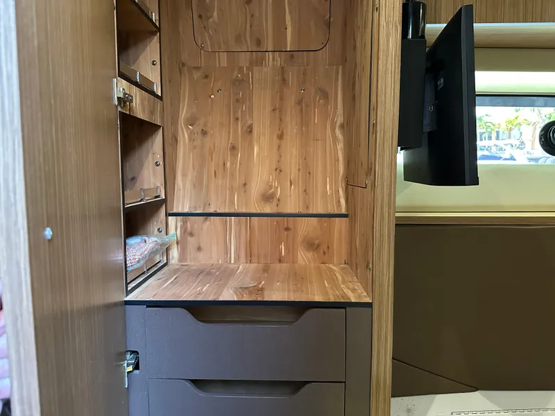 Slide: The Image of Interior of 2016 Sea Ray L590 yacht with wooden cabinetry and mounted TV. - 8