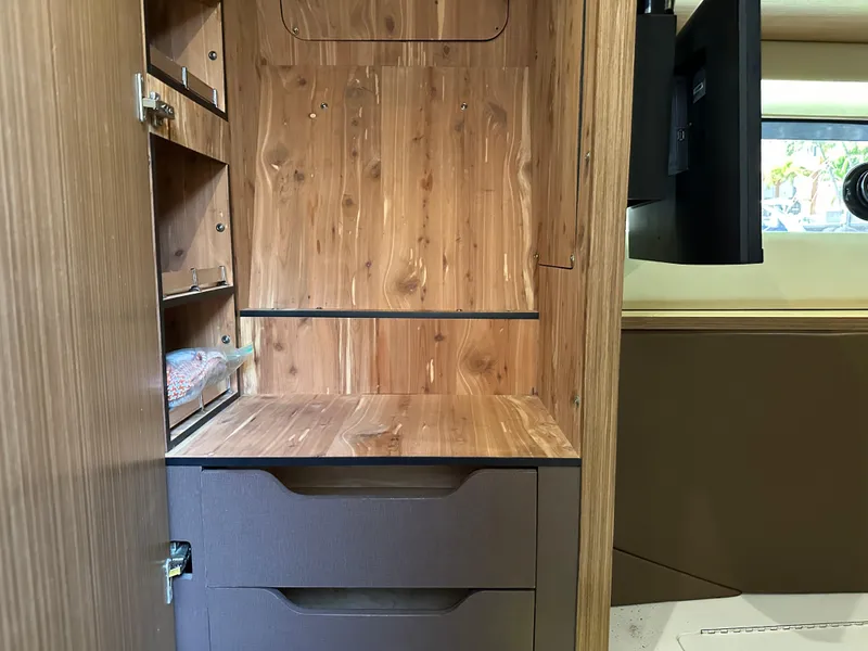 Slide: The Image of Interior of 2016 Sea Ray L590 yacht with wooden cabinetry and storage shelves. - 9