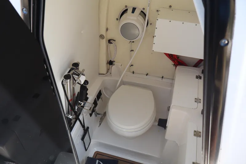 Slide: The Image of 2022 Tidewater 272 LXF boat interior with compact marine toilet and storage. - 12
