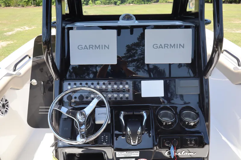 Slide: The Image of 2022 Tidewater 272 LXF boat dashboard with Garmin displays and steering wheel. - 13