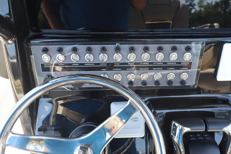 Slide: The Image of Control panel of 2022 Tidewater 272 LXF boat with steering wheel and switches. - 16