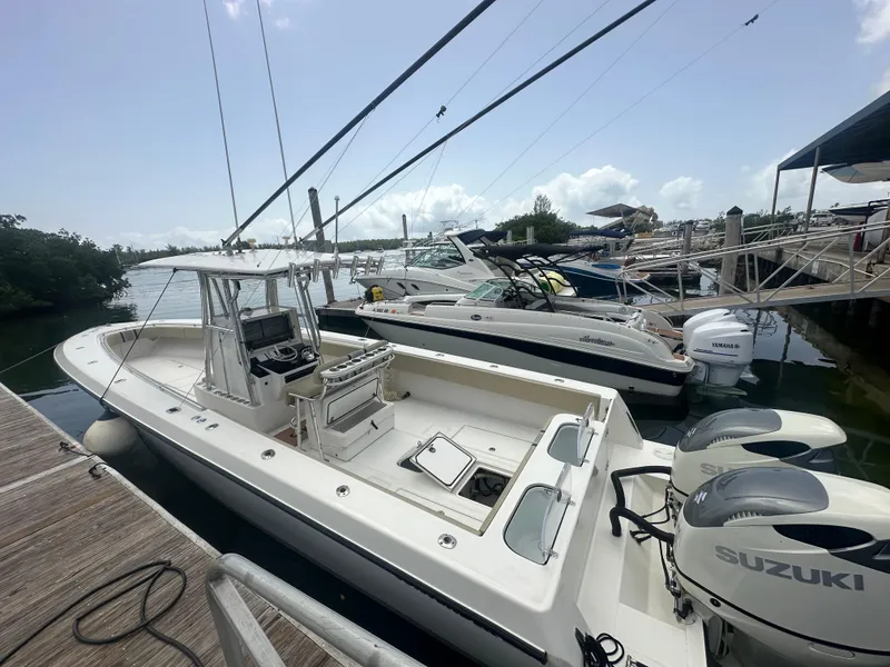 Slide: The Image of 2008 Contender 36 Open boat docked with Suzuki engines, clear sky background. - 12
