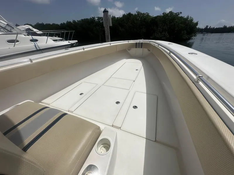 Slide: The Image of 2008 Contender 36 Open boat deck with seating, docked near lush greenery. - 16