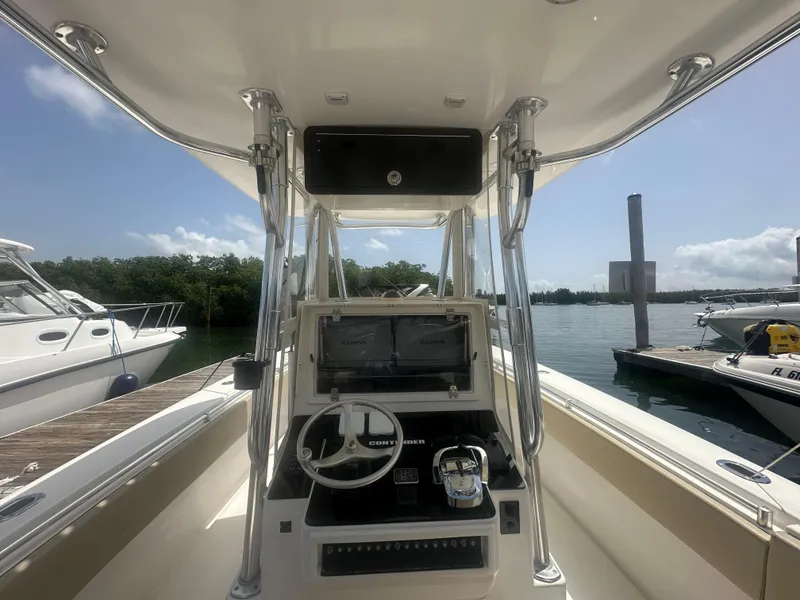 Slide: The Image of 2008 Contender 36 Open boat console with steering wheel and navigation system at a marina. - 21