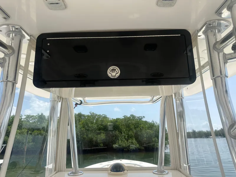 Slide: The Image of 2008 Contender 36 Open boat console with storage compartment, surrounded by water and trees. - 30