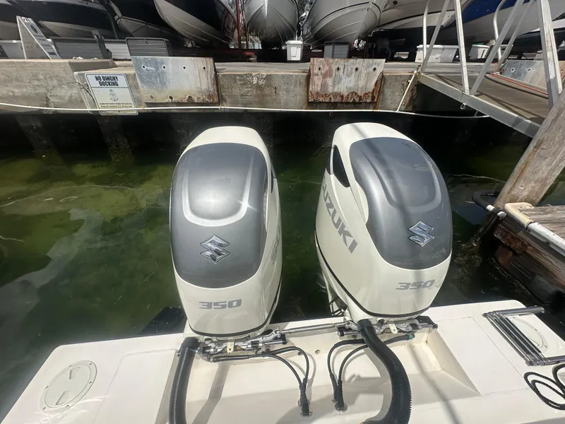 Slide: The Image of Twin Suzuki 350 outboard engines on a 2008 Contender 36 Open boat at a dock. - 57