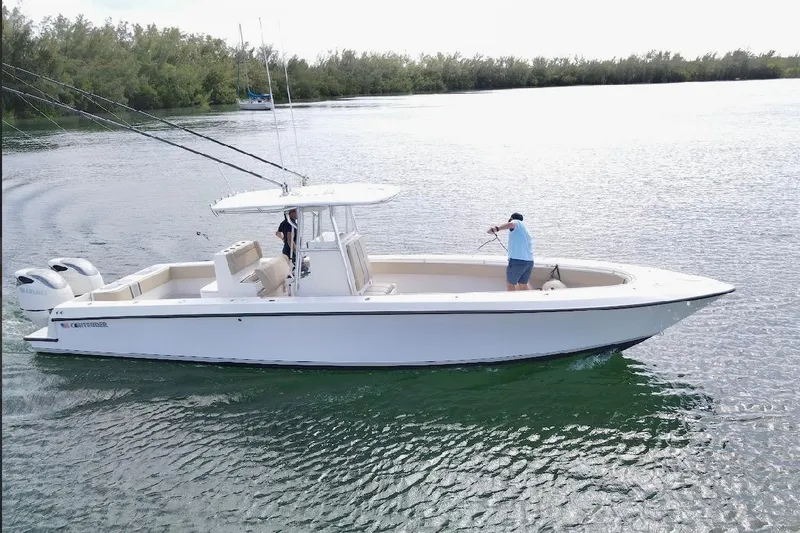 Slide: The Image of 2008 Contender 36 Open boat cruising on a calm lake with two people onboard. - 6