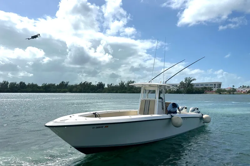 Slide: The Image of 2008 Contender 36 Open boat on water with fishing rods, under a partly cloudy sky. - 64