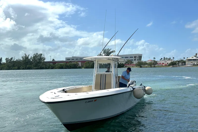 Slide: The Image of 2008 Contender 36 Open boat on water with two people, clear sky background. - 66