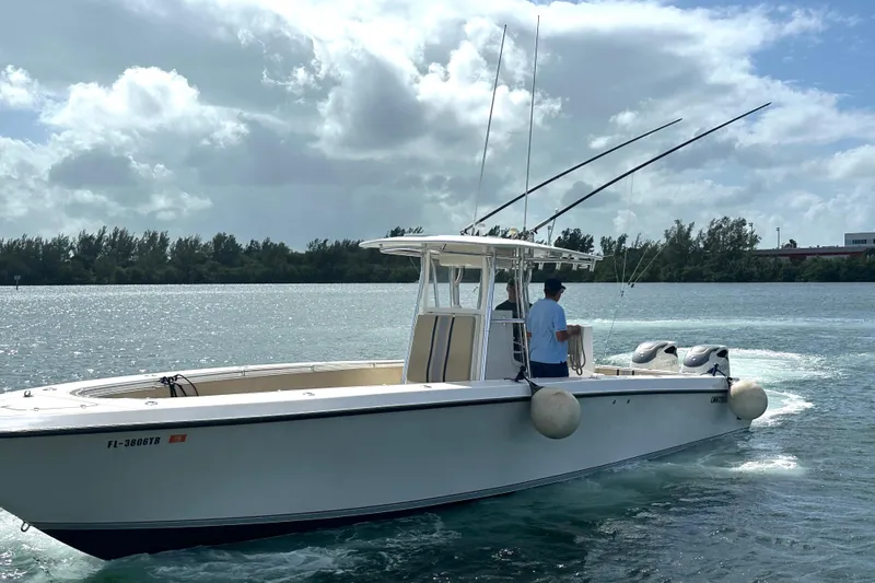 Slide: The Image of 2008 Contender 36 Open boat on water, equipped with fishing rods, under cloudy sky. - 68