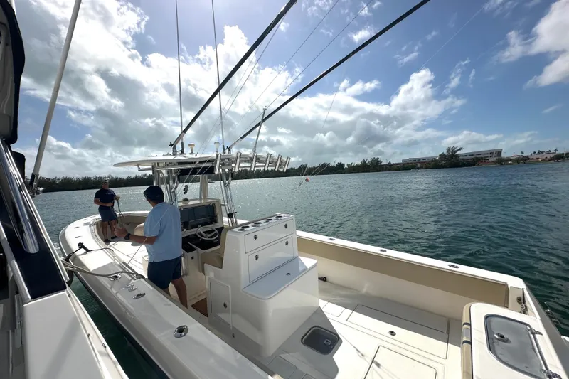 Slide: The Image of 2008 Contender 36 Open boat on water with two people, clear sky, and scenic view. - 72
