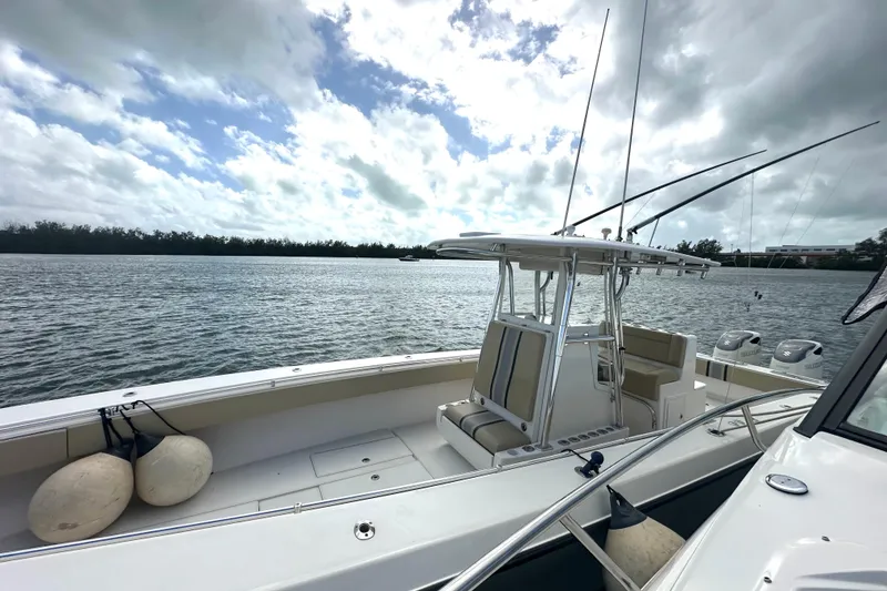 Slide: The Image of 2008 Contender 36 Open boat on calm water, featuring fishing rods and spacious deck. - 75