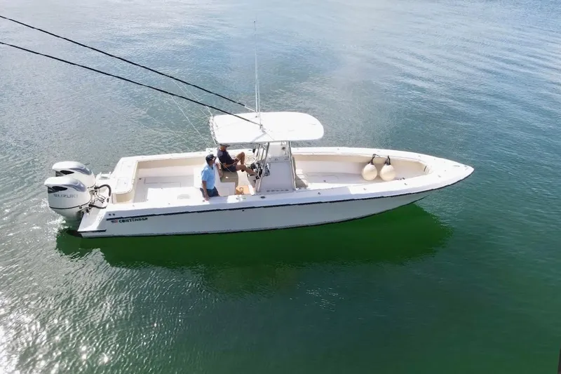 Slide: The Image of 2008 Contender 36 Open boat on calm water, featuring dual Suzuki engines. - 83