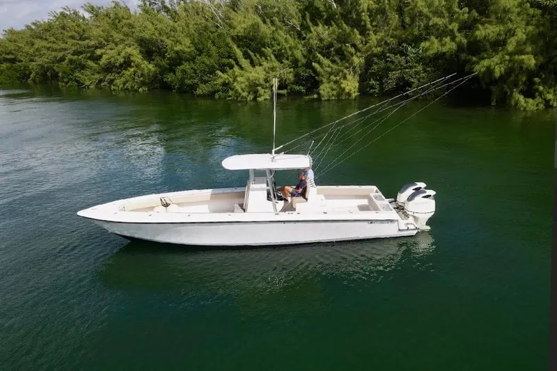 Slide: The Image of 2008 Contender 36 Open boat on calm water, surrounded by lush greenery. - 84