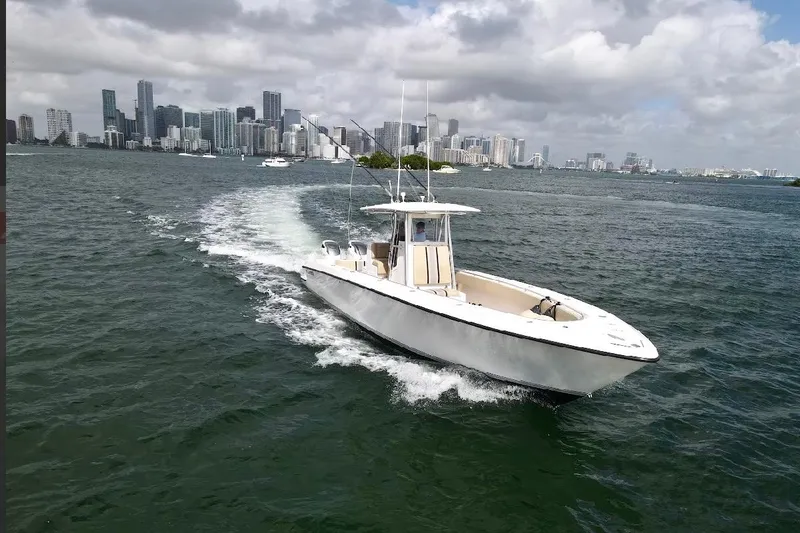 Slide: The Image of 2008 Contender 36 Open boat cruising near city skyline under cloudy sky. - 88