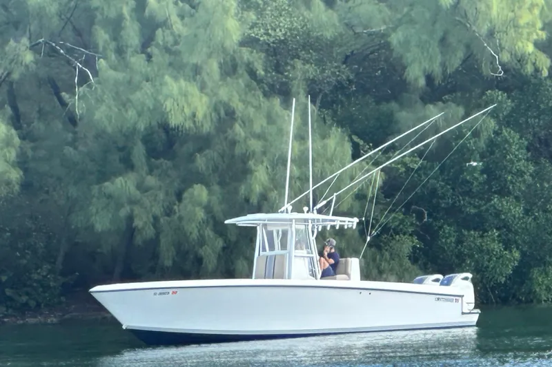 Slide: The Image of 2008 Contender 36 Open boat on calm water, surrounded by lush greenery. - 89