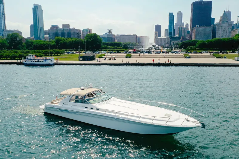 The Image of 1997 Sea Ray 630 Super Sun Sport yacht cruising near city skyline. - 16