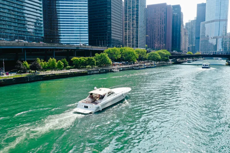 Slide: The Image of 1997 Sea Ray 630 Super Sun Sport yacht cruising in urban river with city skyline. - 19