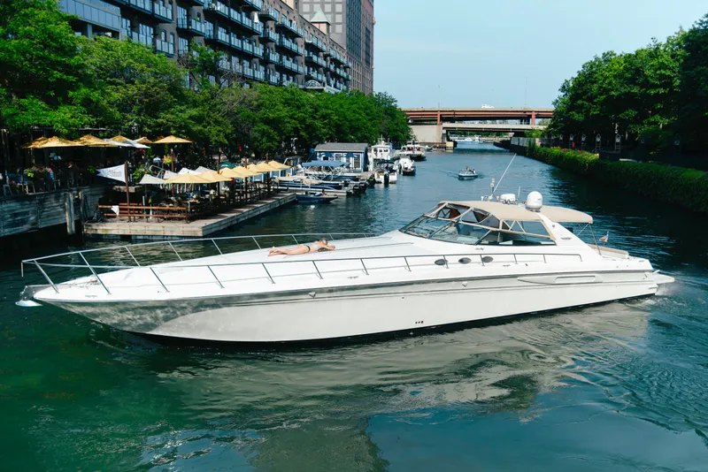 Slide: The Image of 1997 Sea Ray 630 Super Sun Sport yacht cruising in a scenic urban canal. - 28