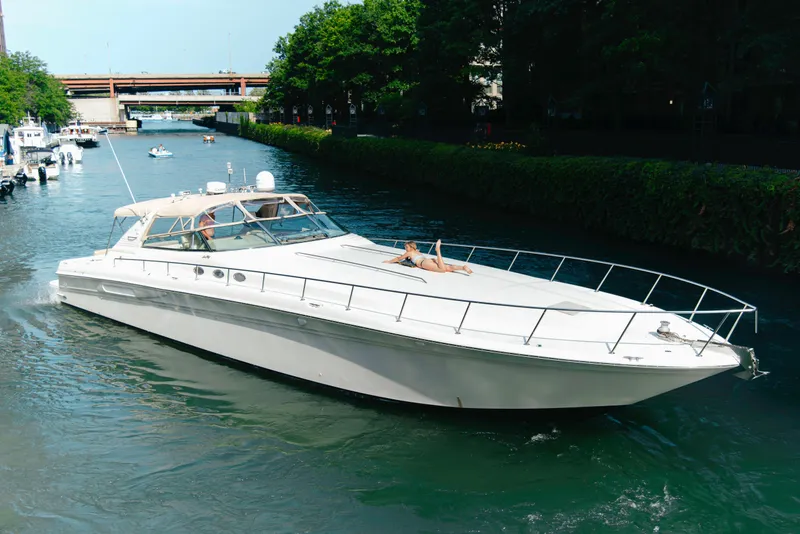 Slide: The Image of 1997 Sea Ray 630 Super Sun Sport yacht cruising on a scenic waterway. - 29