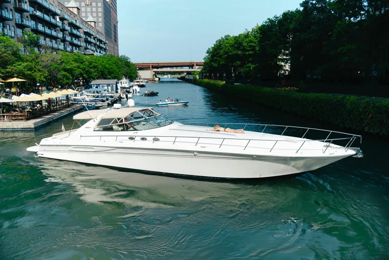 Slide: The Image of 1997 Sea Ray 630 Super Sun Sport yacht cruising on a scenic urban waterway. - 30