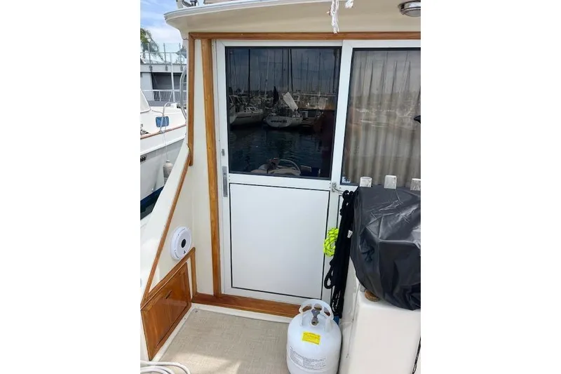 Slide: The Image of 1981 Viking 35 Convertible boat deck with sliding door and marina view. - 10