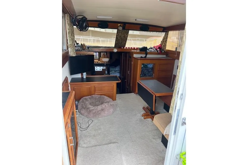 Slide: The Image of 1981 Viking 35 Convertible boat interior with wood furnishings and cozy seating area. - 12