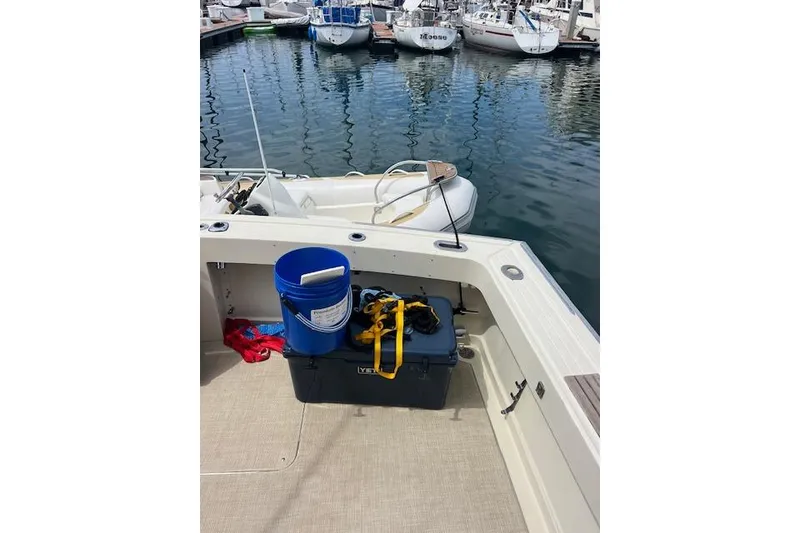 Slide: The Image of 1981 Viking 35 Convertible boat deck with blue bucket and storage box at marina. - 16