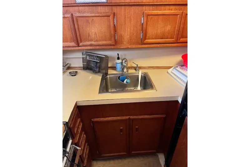 Slide: The Image of 1981 Viking 35 Convertible kitchen with wooden cabinets and stainless steel sink. - 25