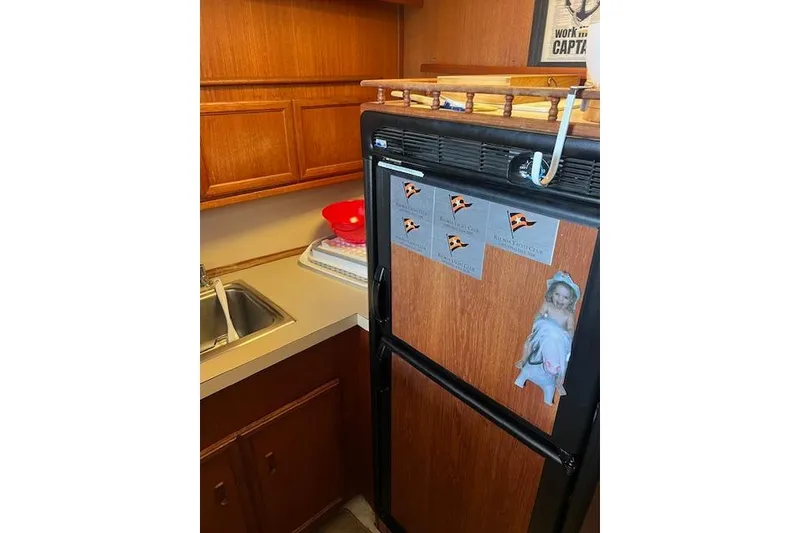 Slide: The Image of 1981 Viking 35 Convertible kitchen with wooden cabinets and a compact fridge. - 26