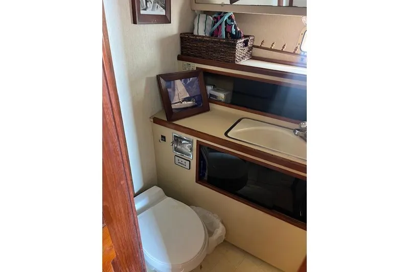 Slide: The Image of 1981 Viking 35 Convertible yacht bathroom with sink, toilet, and framed photo. - 27