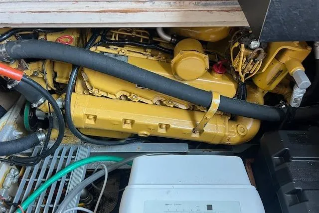 Slide: The Image of Engine compartment of a 1981 Viking 35 Convertible boat, showcasing yellow machinery and hoses. - 29