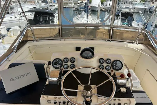 Slide: The Image of 1981 Viking 35 Convertible yacht docked in a marina, surrounded by sailboats. - 4