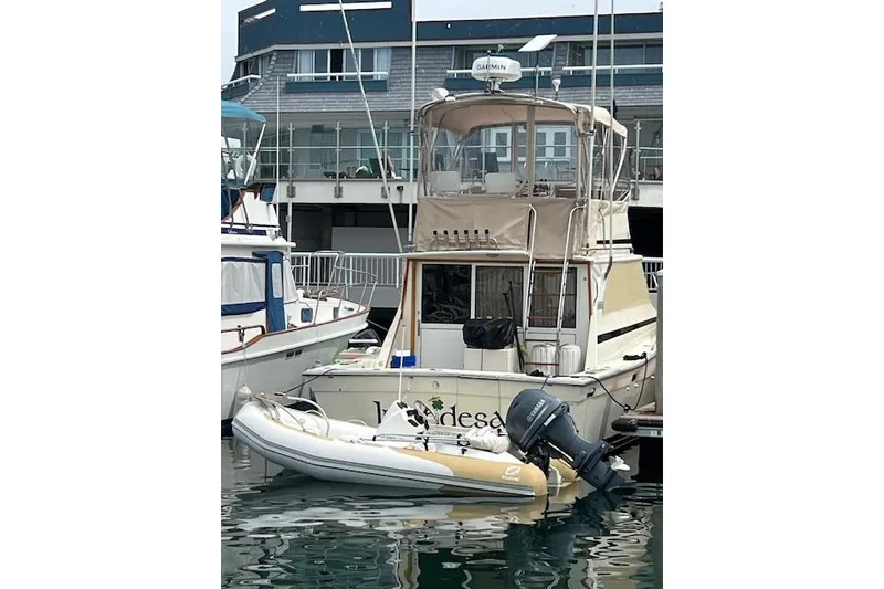 Slide: The Image of 1981 Viking 35 Convertible boat docked with inflatable dinghy attached. - 44