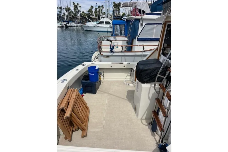 Slide: The Image of 1981 Viking 35 Convertible boat deck with chairs, docked in a marina. - 7